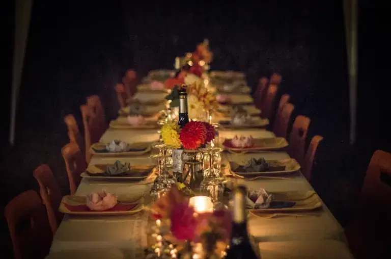 Private dinner party with styled tables, coordinated service, lighting, and guest seating